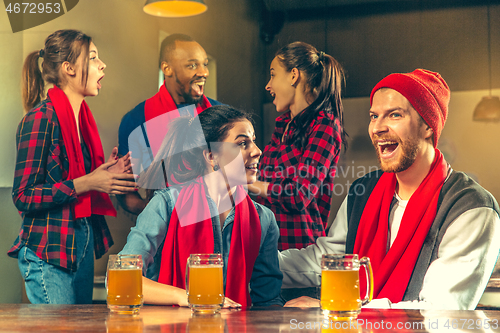 Image of Sport, people, leisure, friendship and entertainment concept - happy football fans or male friends drinking beer and celebrating victory at bar or pub