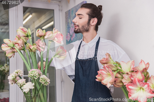 Image of Small business. Male florist in flower shop. Floral design studio, making decorations and arrangements.