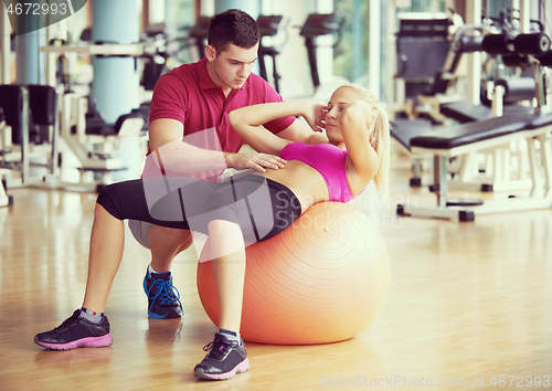 Image of young sporty woman with trainer exercise in fitness gym