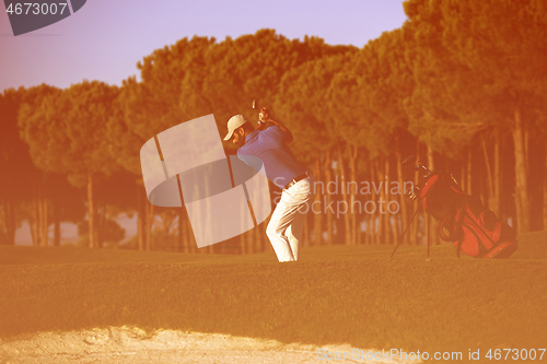 Image of golfer hitting a sand bunker shot on sunset