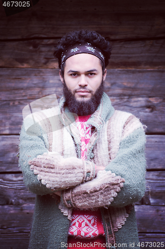 Image of portrait of young hipster in front of wooden house