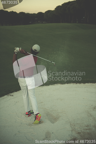 Image of golfer hitting a sand bunker shot on sunset