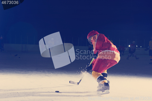 Image of teen ice hockey player in action