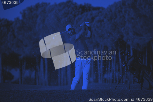 Image of golfer hitting a sand bunker shot on sunset