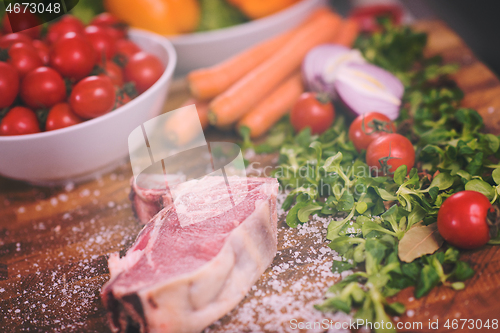 Image of Juicy slice of raw steak on wooden table