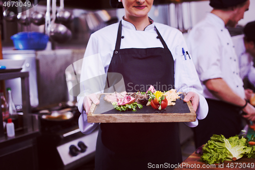 Image of female Chef holding beef steak plate