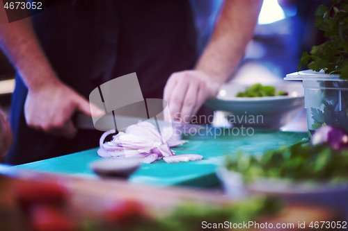 Image of Chef  hands cutting the onion with knife