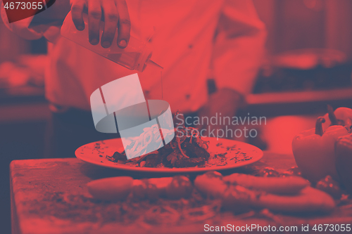 Image of Chef finishing steak meat plate