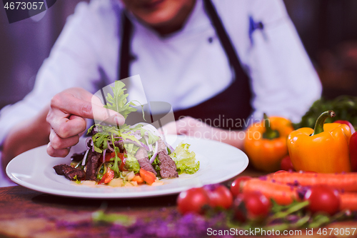 Image of cook chef decorating garnishing prepared meal