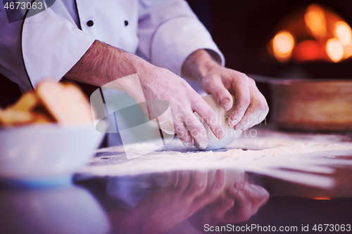 Image of chef hands preparing dough for pizza