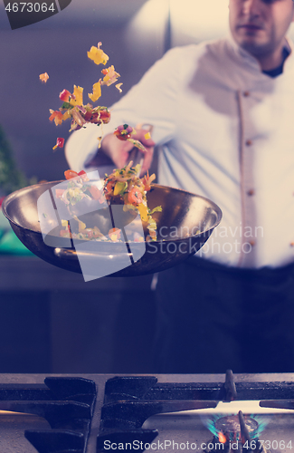 Image of chef flipping vegetables in wok