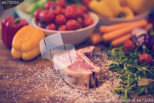 Image of Juicy slice of raw steak on wooden table