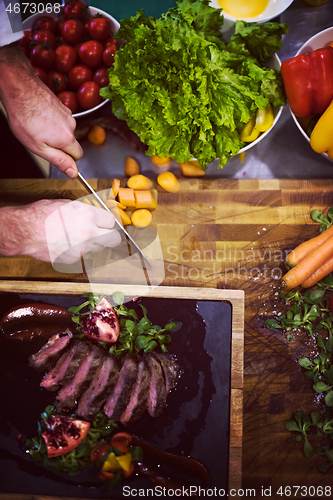 Image of top view of Chef hands serving beef steak