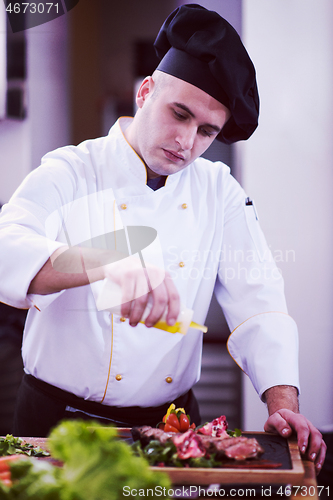 Image of Chef finishing steak meat plate