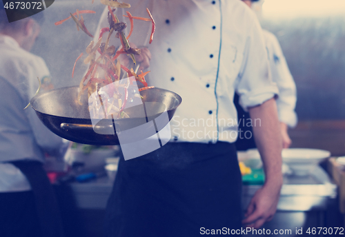 Image of chef flipping vegetables in wok