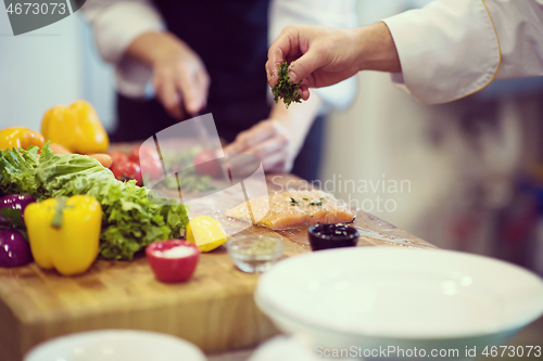Image of Chef hands preparing marinated Salmon fish