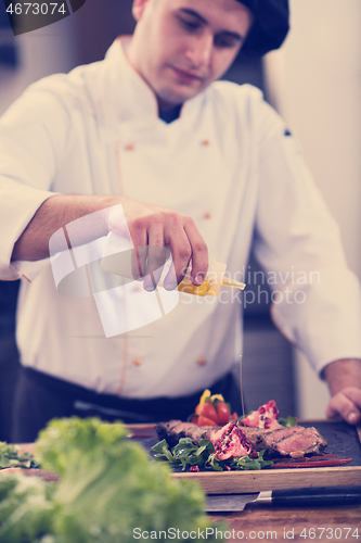 Image of Chef finishing steak meat plate