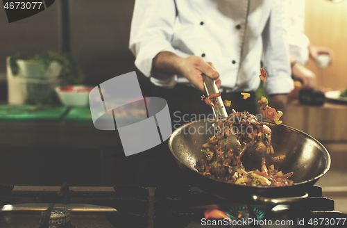 Image of chef flipping vegetables in wok