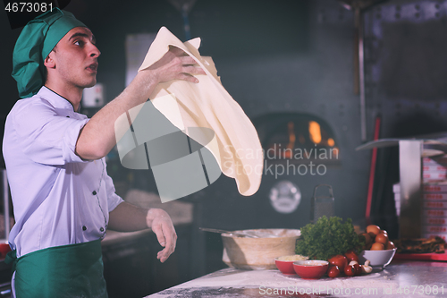 Image of chef throwing up pizza dough