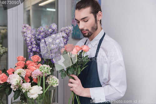 Image of Small business. Male florist in flower shop. Floral design studio, making decorations and arrangements.