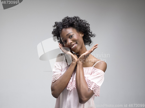 Image of The happy african woman standing and smiling against gray background.