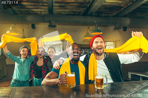 Image of Sport, people, leisure, friendship and entertainment concept - happy football fans or male friends drinking beer and celebrating victory at bar or pub