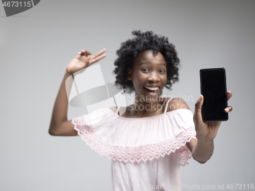 Image of Portrait of a confident casual afro girl showing blank screen mobile phone