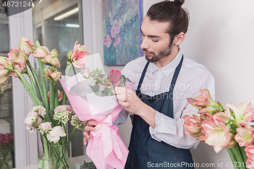 Image of Small business. Male florist in flower shop. Floral design studio, making decorations and arrangements.