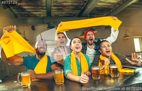 Image of Sport, people, leisure, friendship and entertainment concept - happy football fans or male friends drinking beer and celebrating victory at bar or pub