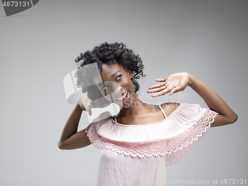 Image of The happy african woman standing and smiling against gray background.