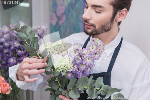 Image of Small business. Male florist in flower shop. Floral design studio, making decorations and arrangements.