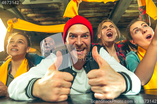 Image of Sport, people, leisure, friendship and entertainment concept - happy football fans or male friends drinking beer and celebrating victory at bar or pub