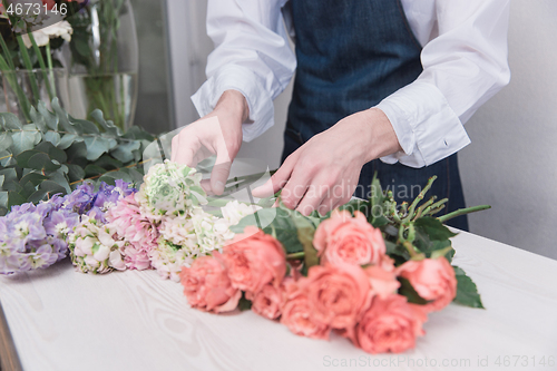 Image of Small business. Male florist in flower shop. Floral design studio, making decorations and arrangements.