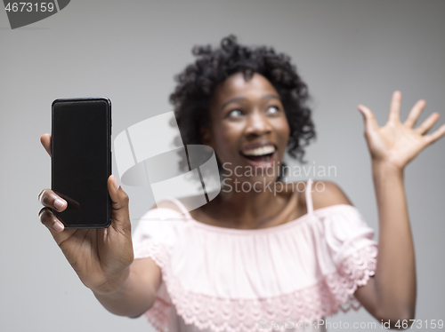 Image of Portrait of a confident casual afro girl showing blank screen mobile phone