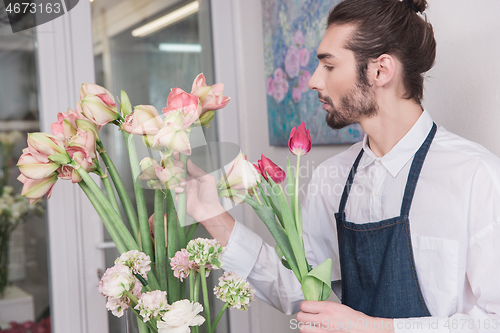 Image of Small business. Male florist in flower shop. Floral design studio, making decorations and arrangements.