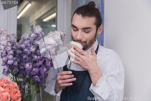 Image of Small business. Male florist in flower shop. Floral design studio, making decorations and arrangements.