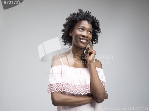 Image of The happy african woman standing and smiling against gray background.