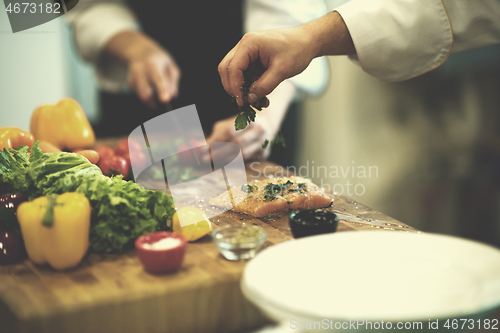 Image of Chef hands preparing marinated Salmon fish