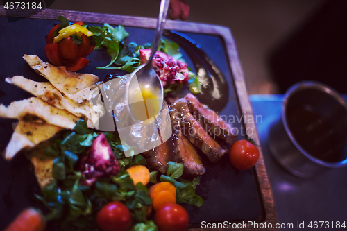 Image of Chef hand finishing steak meat plate