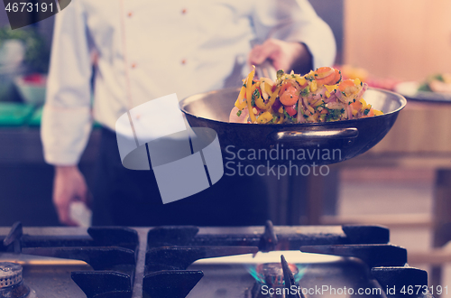 Image of chef flipping vegetables in wok