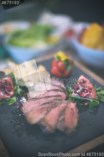 Image of Juicy slices of grilled steak on wooden board