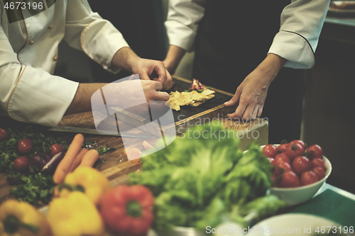 Image of team cooks and chefs preparing meal