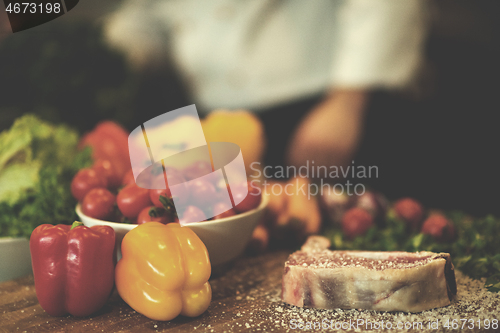 Image of Juicy slice of raw steak on wooden table