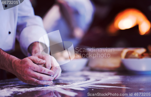 Image of chef hands preparing dough for pizza