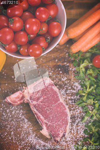 Image of top view of raw steak on wooden table