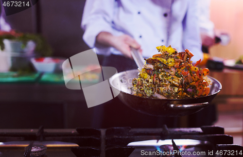 Image of chef flipping vegetables in wok