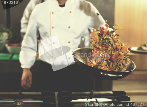 Image of chef flipping vegetables in wok