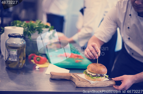 Image of chef finishing burger