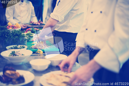 Image of team cooks and chefs preparing meal