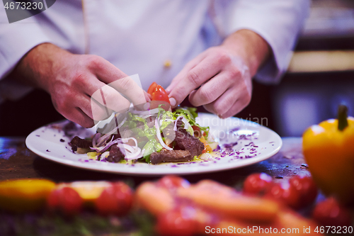 Image of cook chef decorating garnishing prepared meal